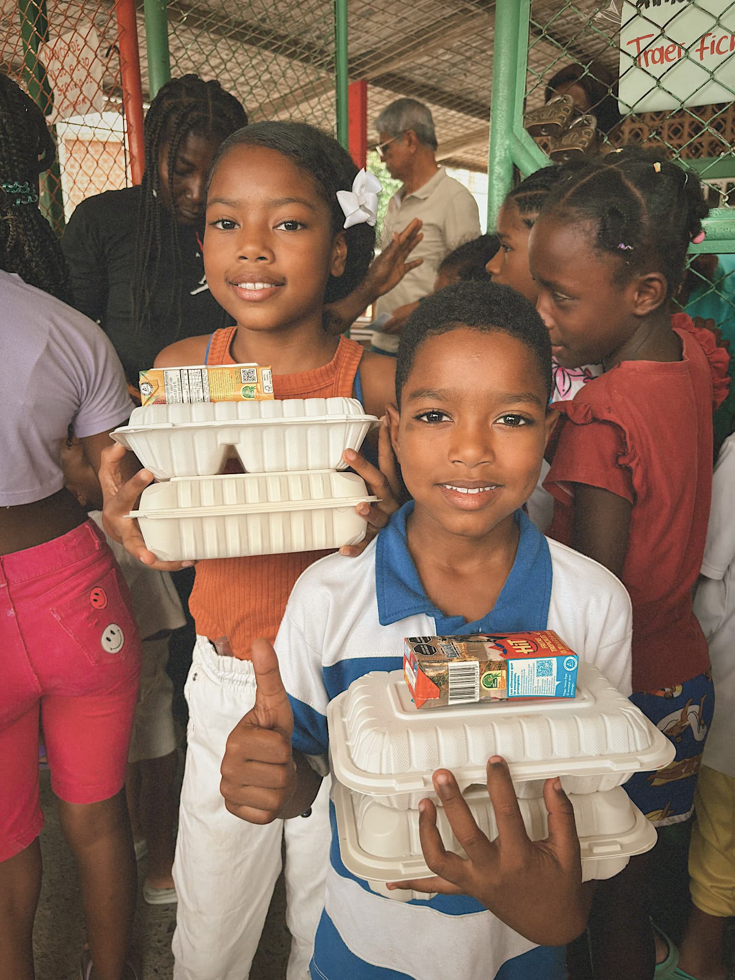 Niños recibiendo almuerzos y jugos en una jornada comunitaria